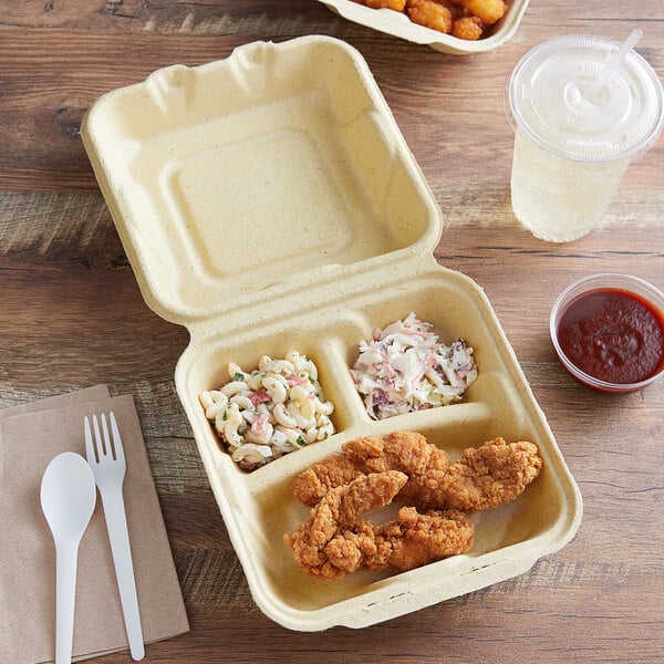 Fabri-Kal Greenware 3-compartment hinged container with chicken strips and salad.