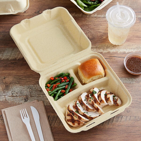 A Fabri-Kal Greenware 3-compartment container with food inside.