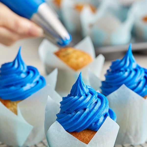 A close up of a cupcake with blue Rich's Buttrcreme icing on top.