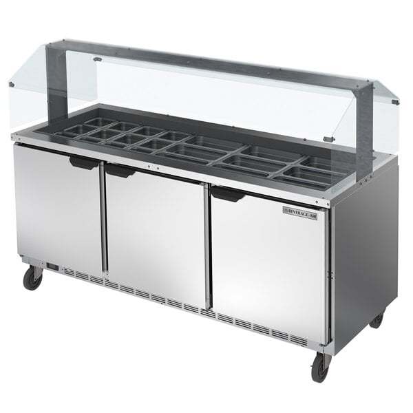 A Beverage-Air stainless steel sneeze guard for a commercial refrigerated food buffet.