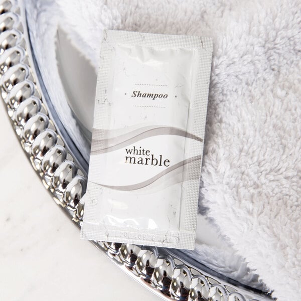 A small white package of Dial White Marble Breck Shampoo on a silver tray.