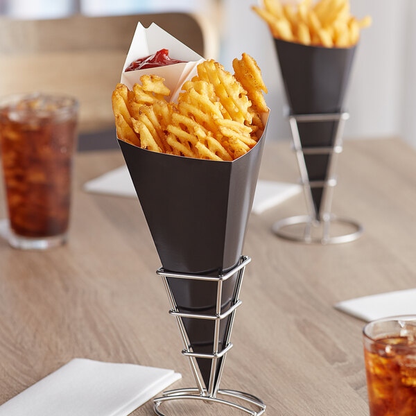 A black Carnival King cardboard cone filled with french fries on a table.
