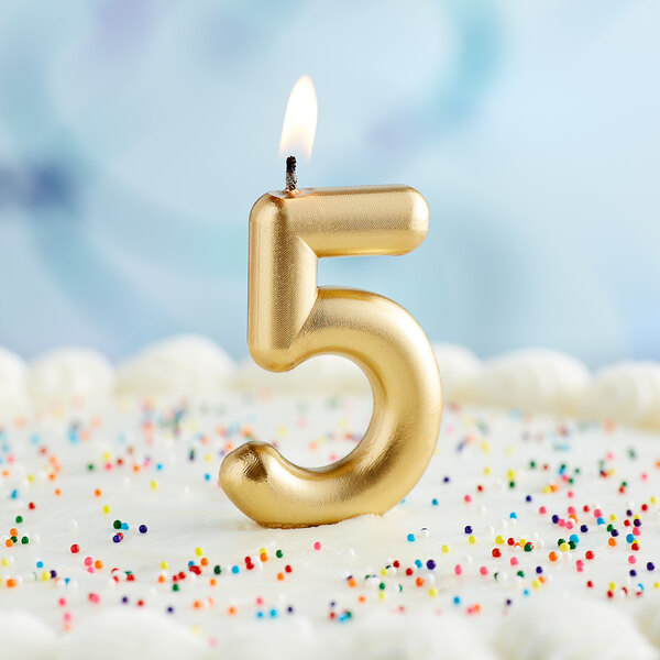 A gold number 5 candle on a blue birthday cake.