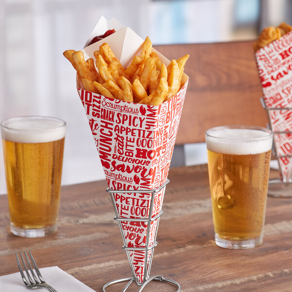 A Carnival King square cardboard fry cone with red text filled with French fries on a table with glasses of beer.