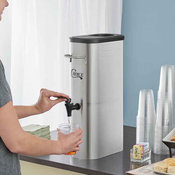 A hand pouring water from a faucet into a Choice 3 Gallon Slim Iced Tea Dispenser.
