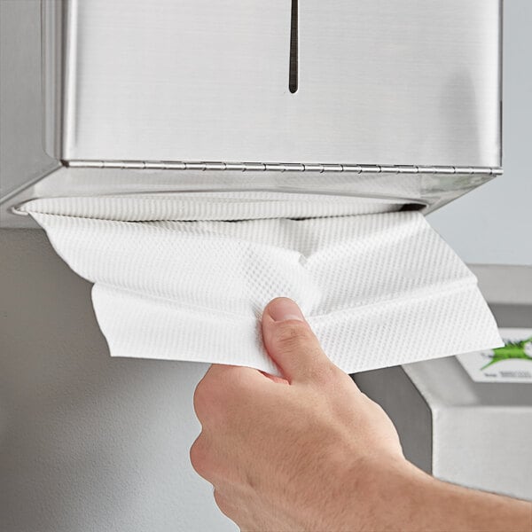 A hand holding a white Lavex C-Fold paper towel.