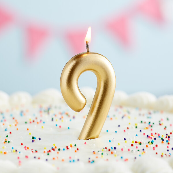 A gold number 9 candle in a cake.