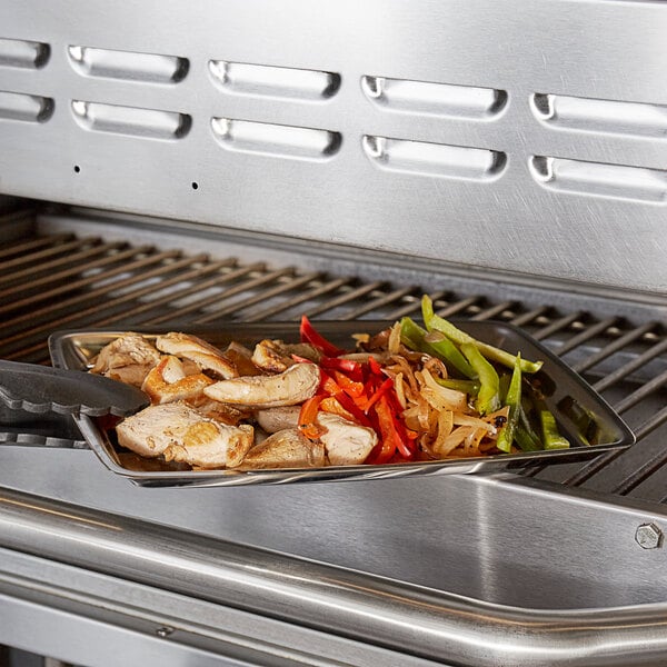 A Choice stainless steel rectangular sizzler platter with food on it being used on a grill.