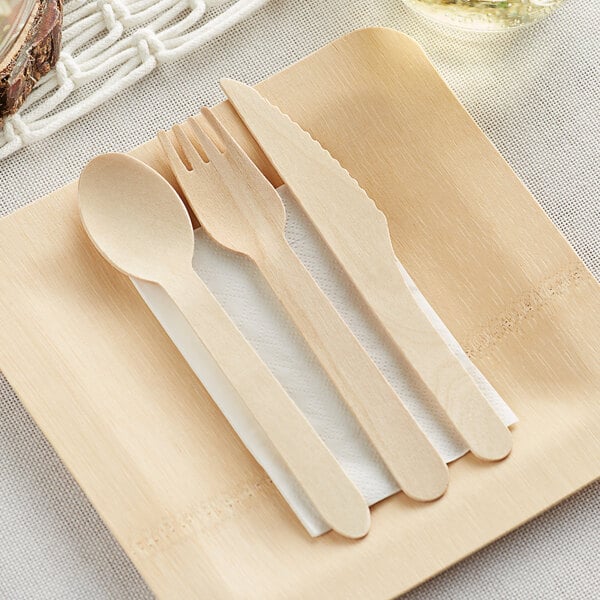 TreeVive by EcoChoice compostable wooden cutlery set on a napkin with a wooden spoon, fork, and knife.