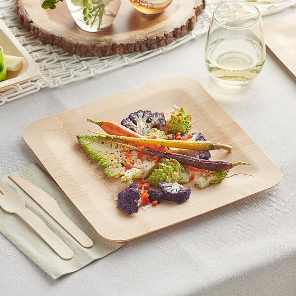 A Bamboo by EcoChoice square plate of vegetables on a table.
