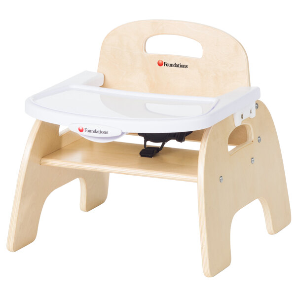 A Foundations natural wood baby feeding chair with tray.