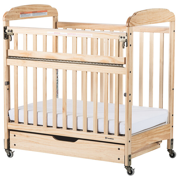 A natural wood sliding crib drawer for a Serenity compact crib.