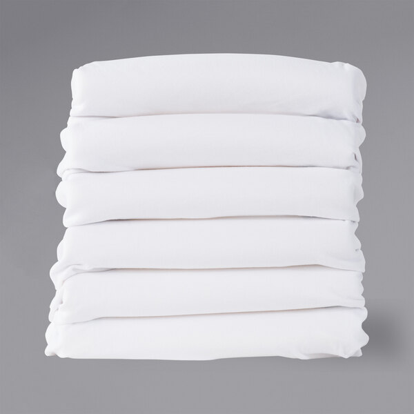 A stack of white rectangular Foundations SafeFit fitted sheets with a white border.
