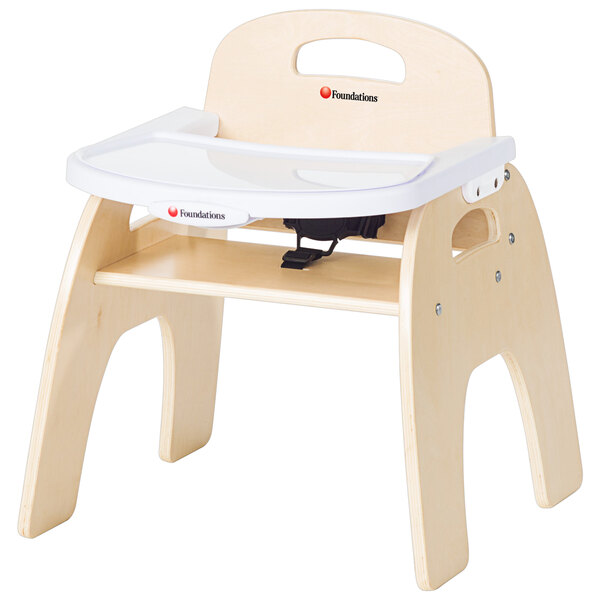 A wooden baby high chair with a wooden and white adjustable tray.