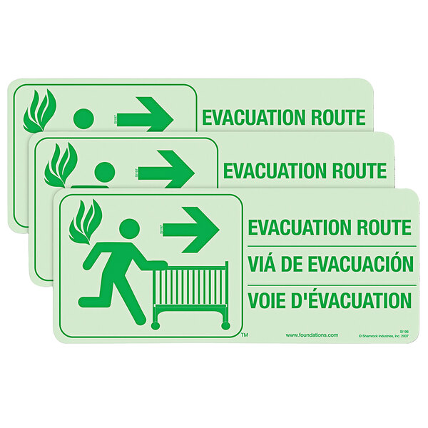 A green and white Foundations First Responder evacuation route sign with green text and an image of a person running with a crib and arrow.