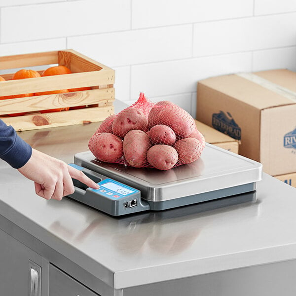 A person weighing a bag of potatoes on an AvaWeigh digital scale.
