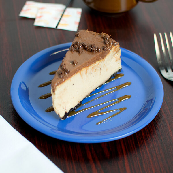 A slice of cheesecake on a Carlisle ocean blue melamine pie plate.