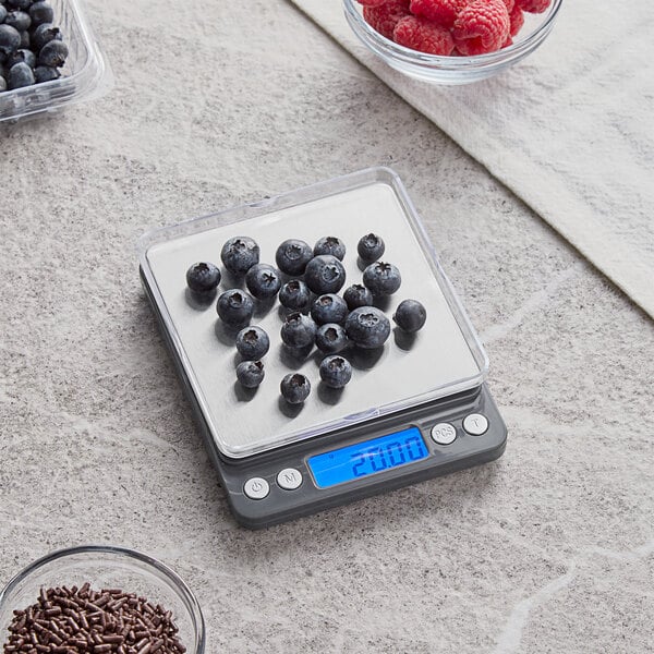 An AvaWeigh high precision digital portion scale with blueberries in a bowl on it.