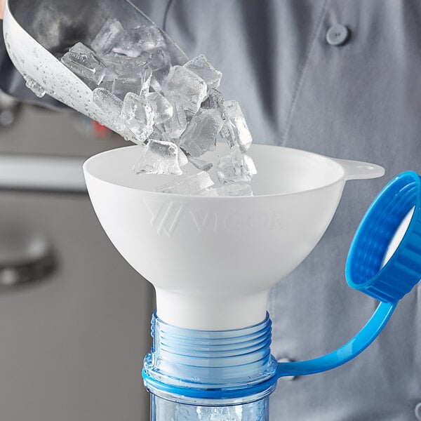 A person pouring ice into a white funnel.