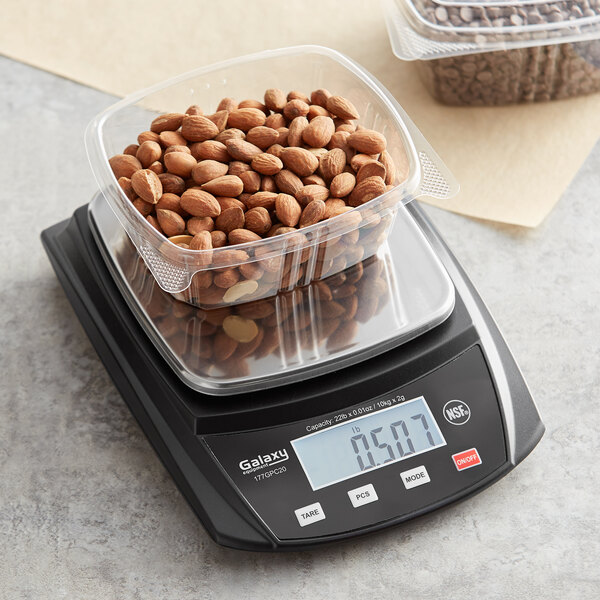 A plastic container of almonds on a Galaxy PC22 portion scale.