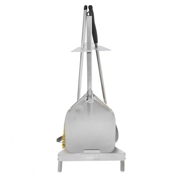 A silver metal GI Metal pizza peel with a handle on a stand.