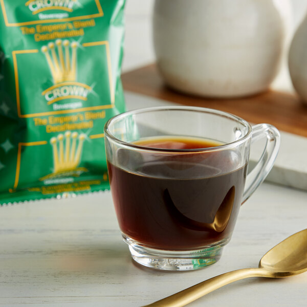 A glass of Crown Beverages Emperor's Blend decaf coffee with a spoon.