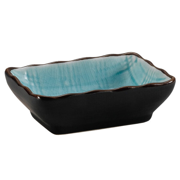A black and blue rectangular stoneware sauce dish with a rippled design.
