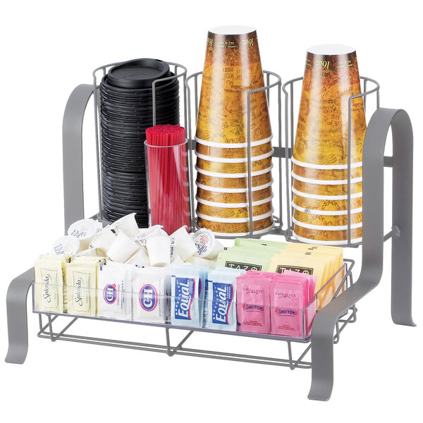 A Cal-Mil Soho silver coffee condiment organizer on a counter with a variety of cups and sugar packets.