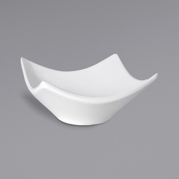 A Front of the House bright white square porcelain bowl on a gray surface.