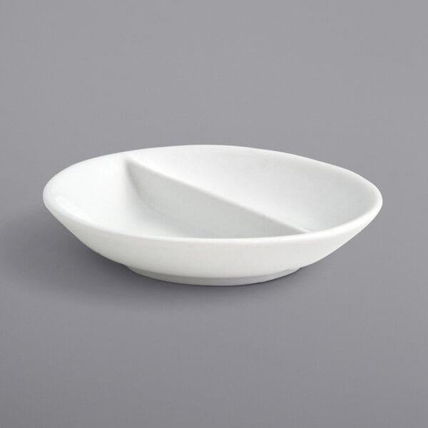 A white round porcelain ramekin with two sections and two handles.