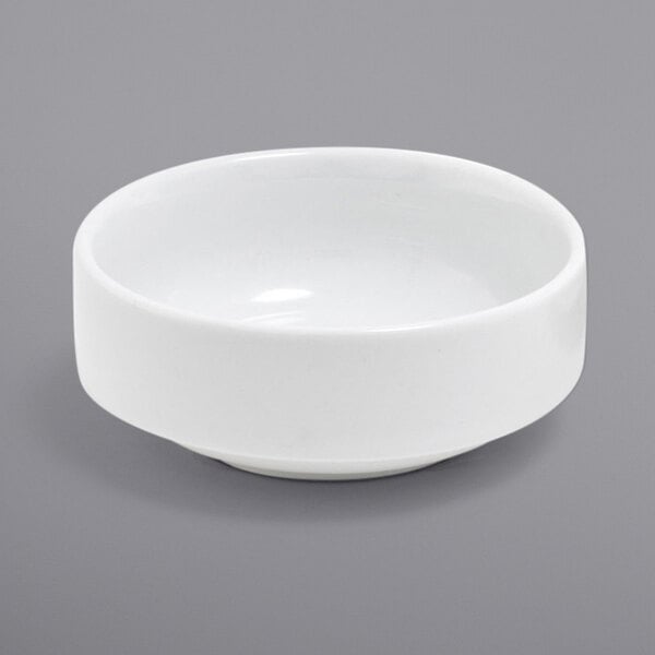 A Front of the House Monaco bright white porcelain ramekin on a gray surface.