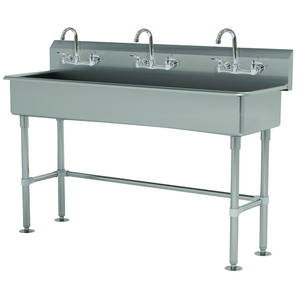 A stainless steel Advance Tabco multi-station hand sink with 3 faucets.