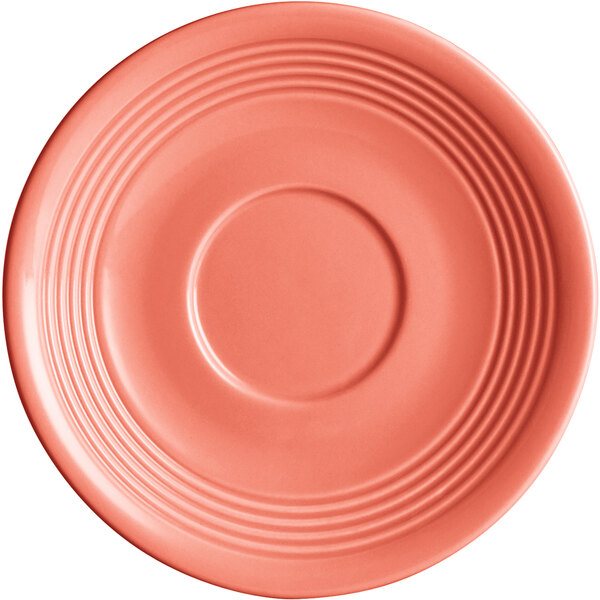 A close-up of an Acopa Capri coral reef saucer with a ruffled rim and a circular pattern in pink.