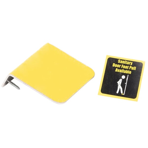 A yellow stainless steel Vollrath hands-free foot door opener with a sticker on it showing a person using it.