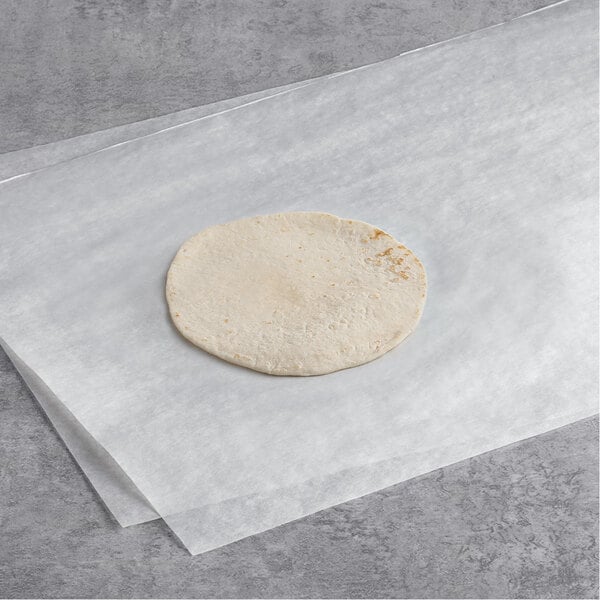 A round white tortilla on a white paper.
