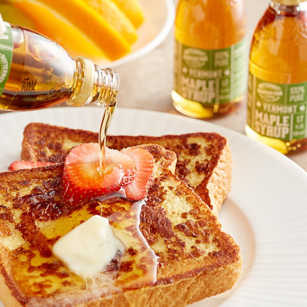 A bottle of Butternut Mountain Farm Grade A Amber Pure Vermont Maple Syrup being poured onto french toast.