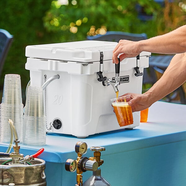 A person pouring a beer from a CaterGator beer dispenser into a cooler.