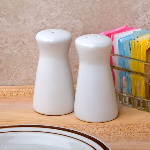 A white table with American Metalcraft ceramic tower salt and pepper shakers.