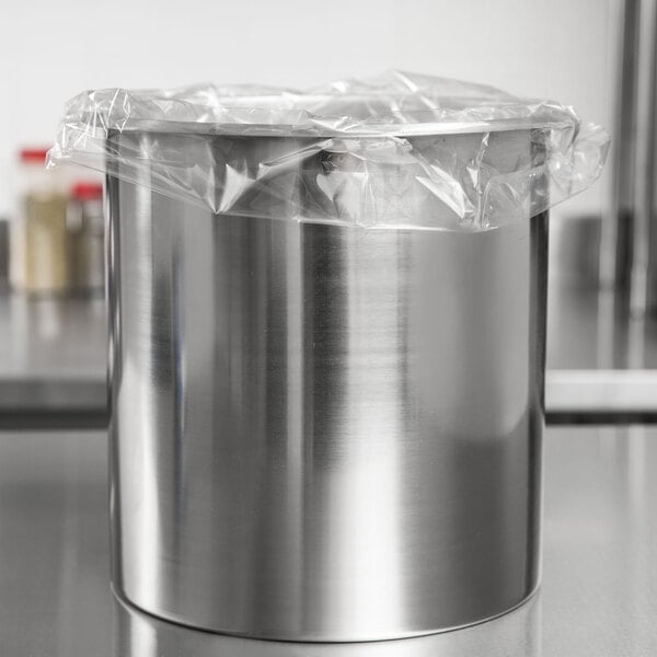 An Avantco stainless steel bain marie pot with plastic wrap on top.