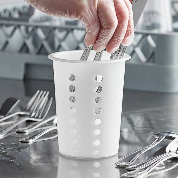A white plastic cylinder with silverware inside and holes in the sides.