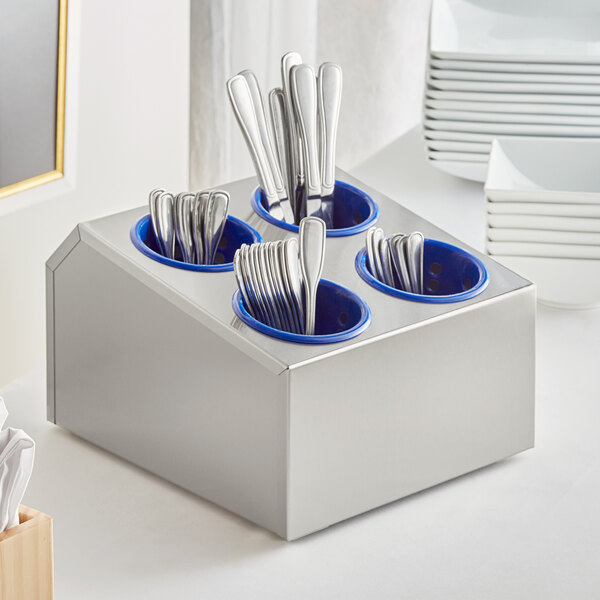 A Choice stainless steel flatware organizer with blue perforated plastic cylinders holding silverware.
