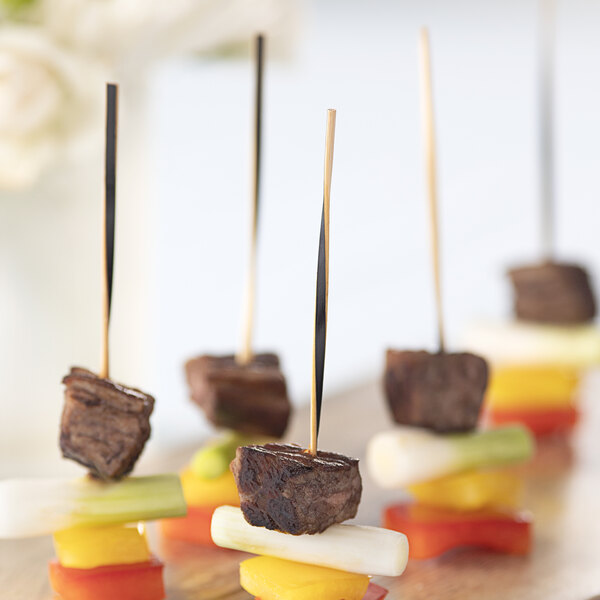 A skewer of meat and vegetables on a wooden board.