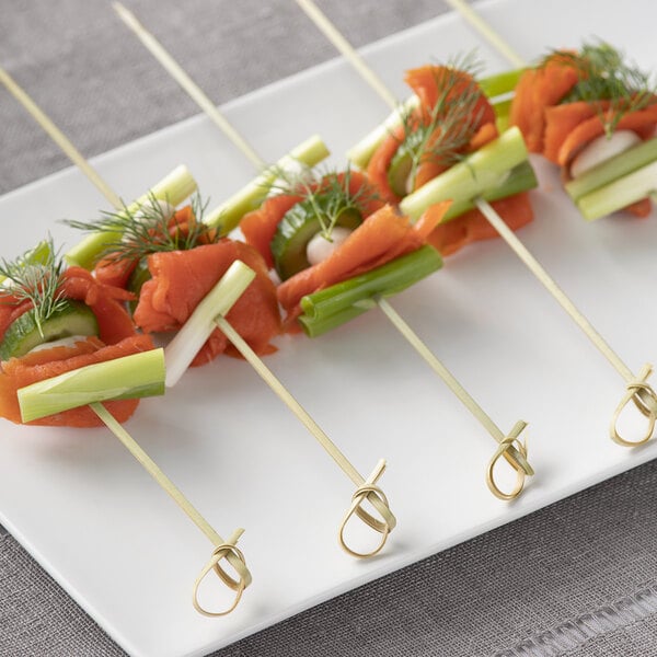 Bamboo food skewers with smoked salmon on a plate.