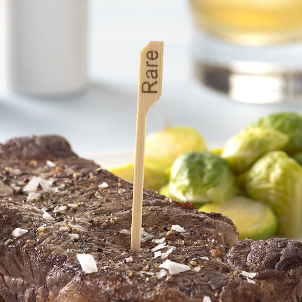 A piece of meat with a Bamboo by EcoChoice "Rare" Meat Marker sticking out of it.