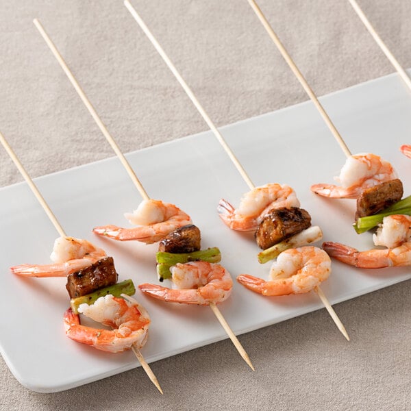 A plate of shrimp and vegetables and meat on EcoChoice bamboo skewers.