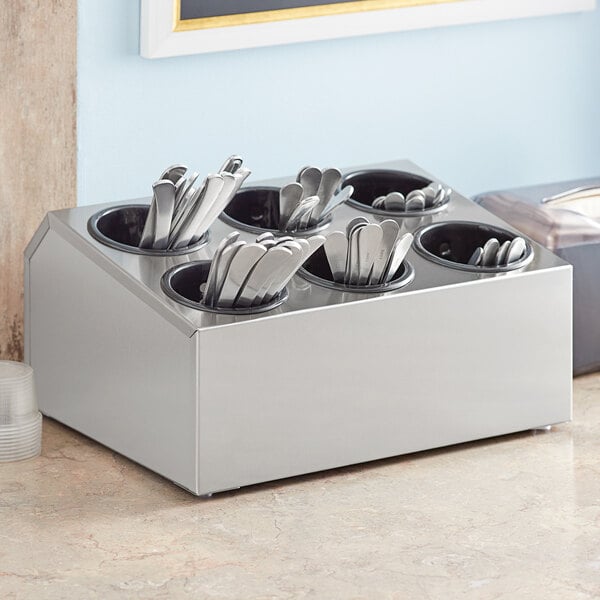 Stainless steel flatware organizer with black perforated plastic cylinders holding silverware.