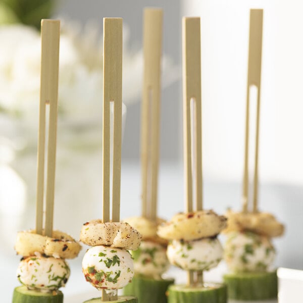 Bamboo skewers with food on them on a white plate.