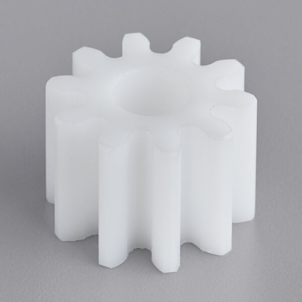 A white plastic gear with a hole in the middle.