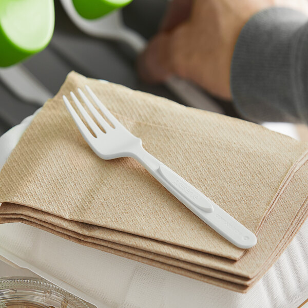 A white plastic fork from Preserve on a stack of napkins.