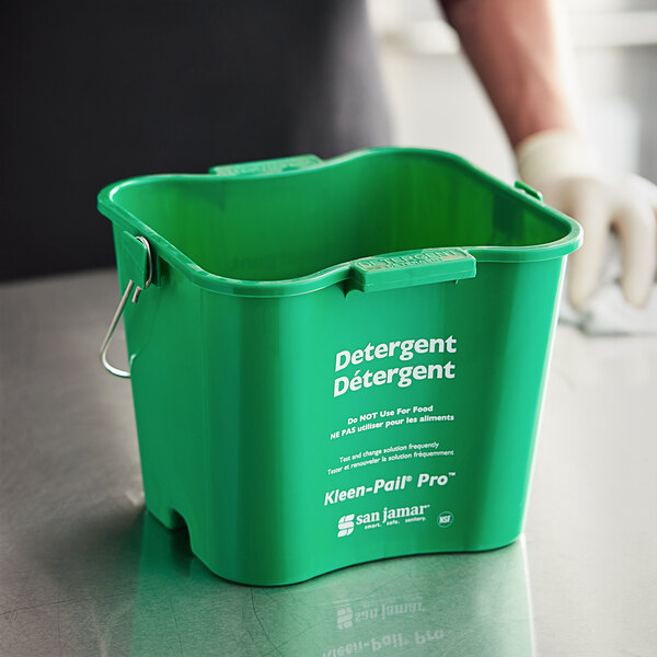 A close-up of a green San Jamar Cleaning Kleen-Pail Pro bucket with white text on it.